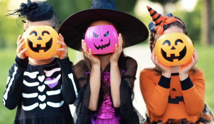 Kids holding Halloween pumpkins over faces