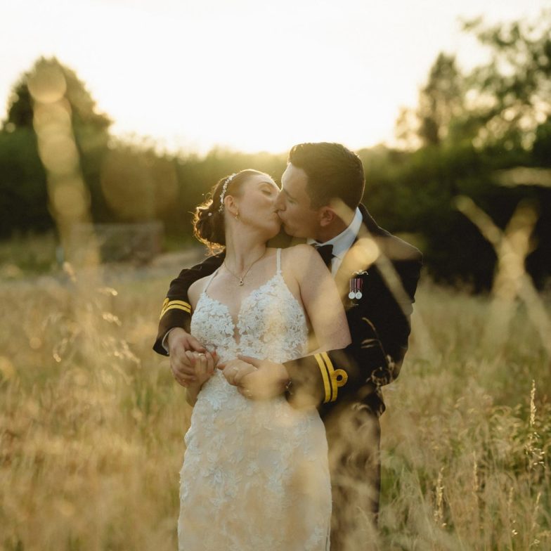 Bride and Groom kissing in a field